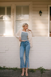 a lady wears a pair of flared jeans with stiped knitted top